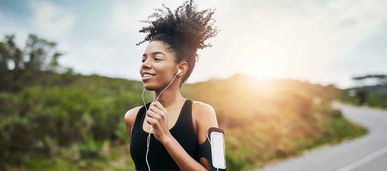 Woman running outside with headphones on